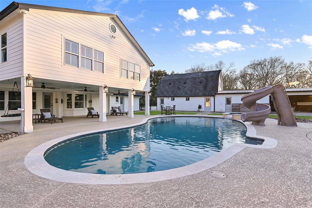Step outside to enjoy a true oasis that includes a sparkling pool and spa with travertine coping and ample stamped concrete cool decking. Relax beneath the covered patio while you watch the little ones slip and slide on the high adventure pool slide.