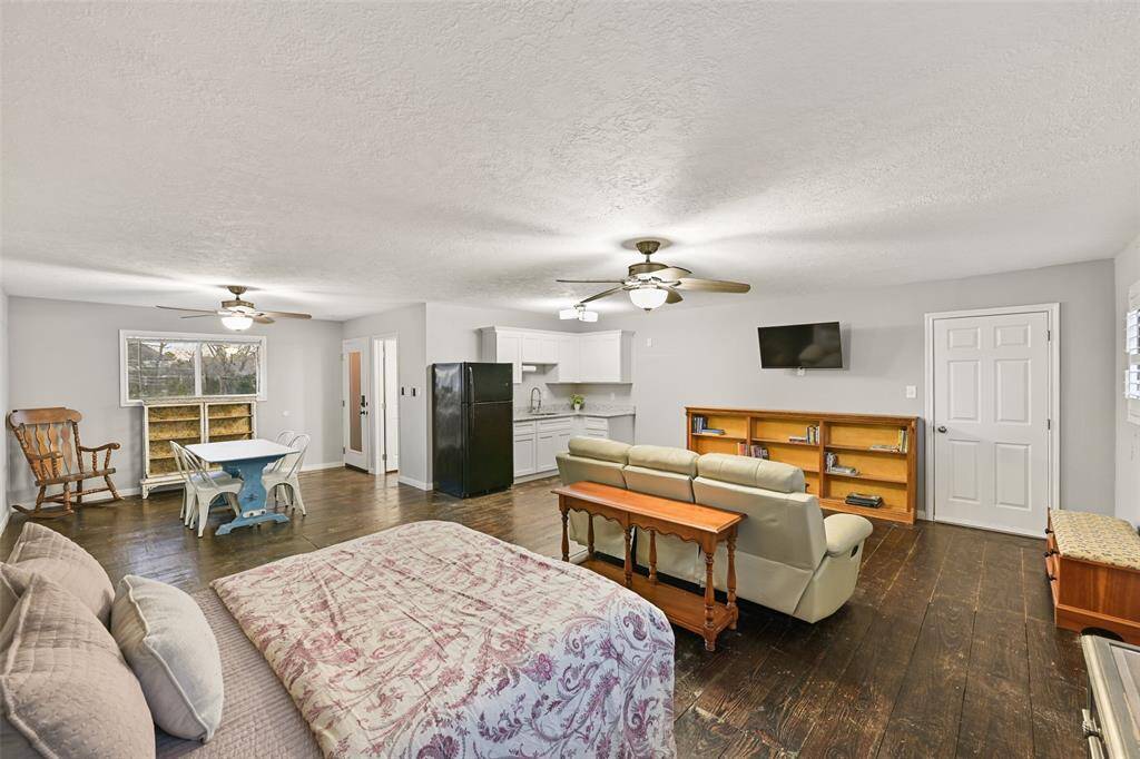 Head up the stairs in the garage to find this 800 SF garage apartment, complete with neutral paint, wood floors, dual ceiling fans, a kitchenette, a closet, and a full bathroom.