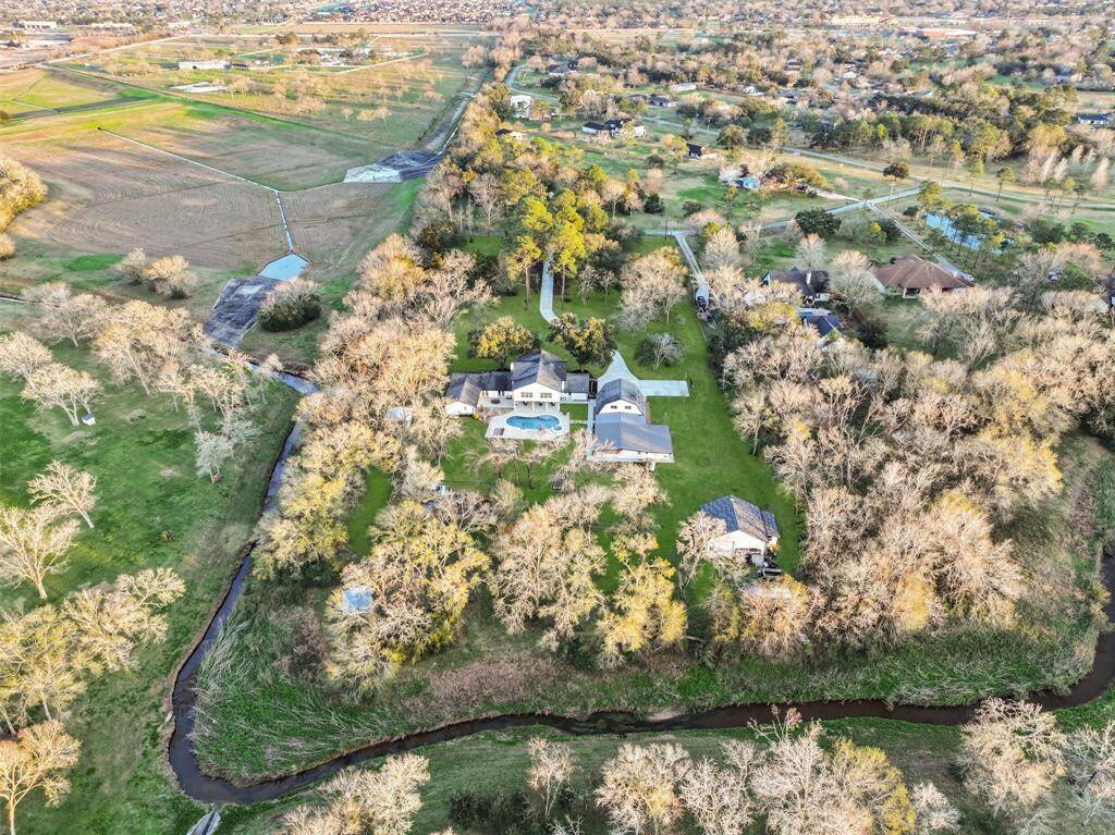 One last glance at this sprawling 4.45-acre property bordered by banks of Chigger Creek highlights over 5,000 square feet of living space and amenities and bonus spaces galore. It's a one-of-a-kind find in Friendswood ISD!