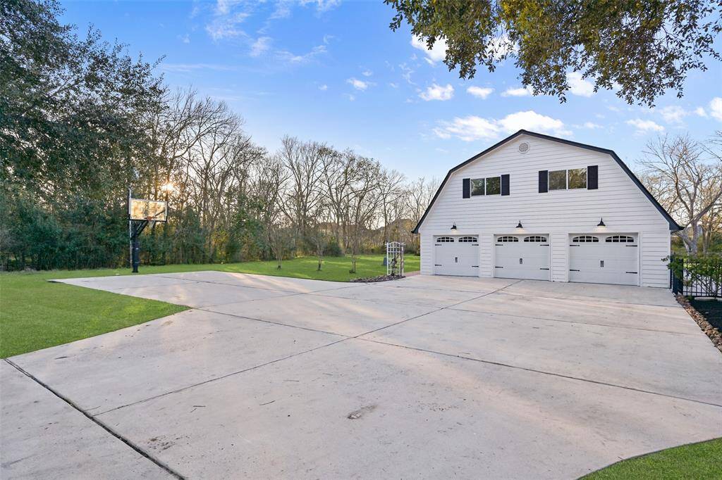 Parking space is in plentiful supply here! Note the oversized parking pad, 3 front-facing garage spaces, several more side-facing garage spaces, and an entire outbuilding behind this one that could house a boat, RV, trailer, or equipment.