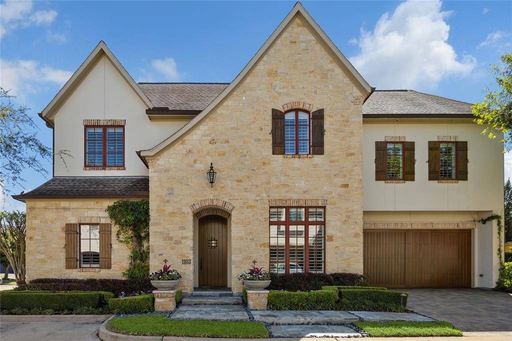 Inviting front elevation of stone with reclaimed antique old Chicago brick window accents. AJ’s Landscaping enhanced this truly custom home with lush greenery and including beautiful planters. The Alder front door is the entre to an inviting entrance into an unmatched space.