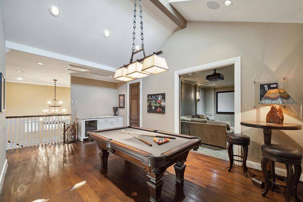 Upstairs game room featuring a vaulted ceiling and counter space with beverage cooler.