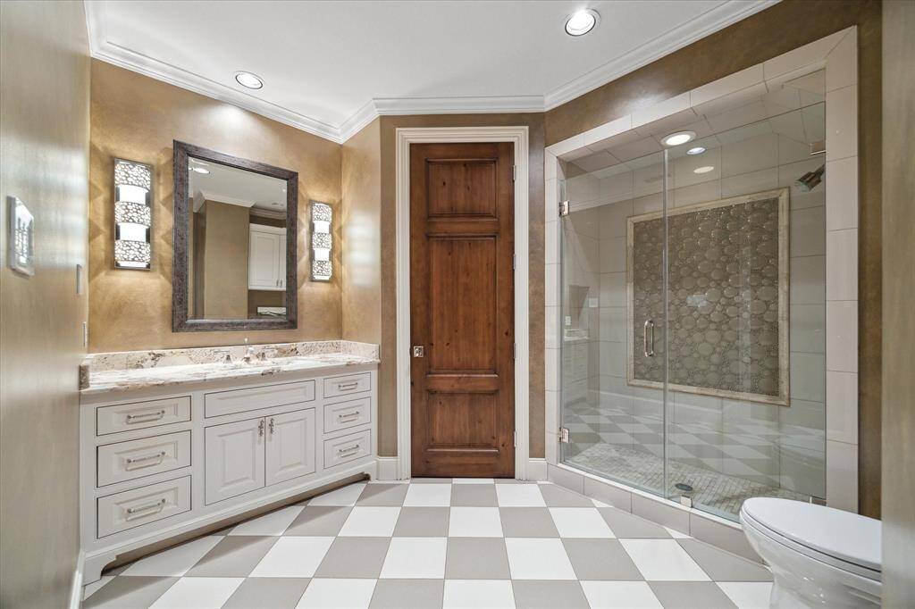Oversized shower, neutral stone counter and appealing tile floors further enhance this en-suite bath.