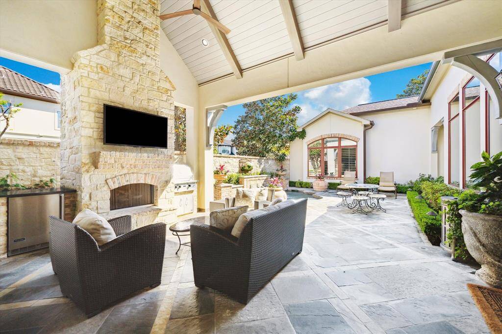 More than a courtyard with impressive limestone fireplace, summer kitchen and vaulted beamed ceiling with shiplap details, this incredible space is well suited for entertaining, college game days  - the possibilities are endless!
