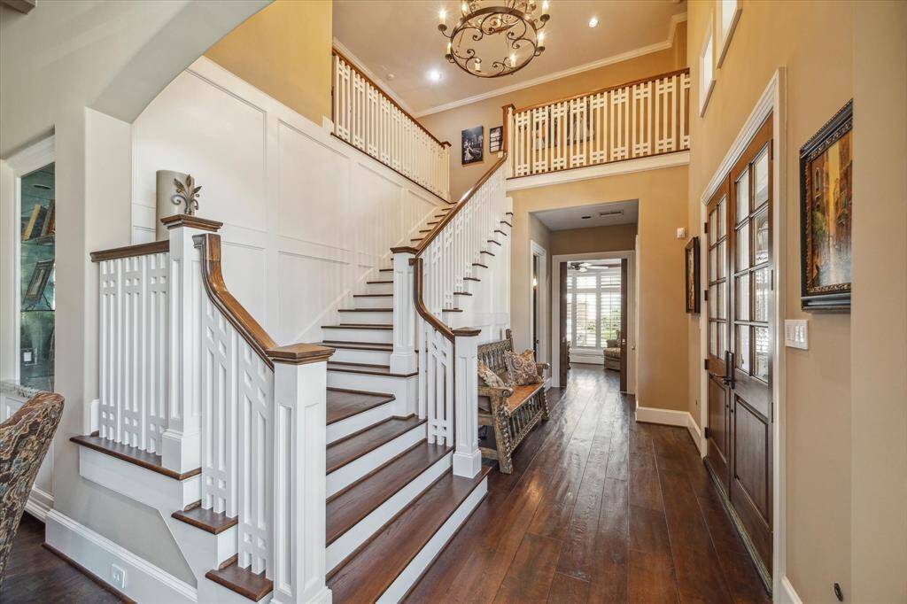 The stunning double doors lead to the custom staircase as you step inside the home.