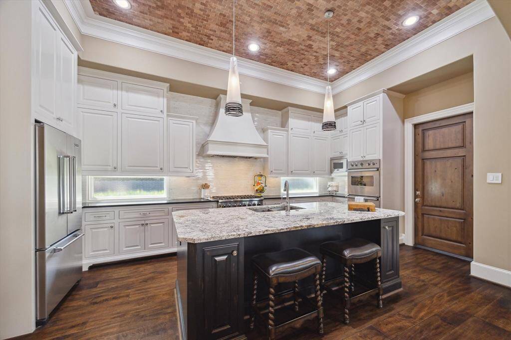 The chefs kitchen with 12' ceilings offers 48 inch gas range, three ovens and refrigerator- all Viking!  The large island houses the sink and abundant storage.  A spacious walk in pantry is nearby,