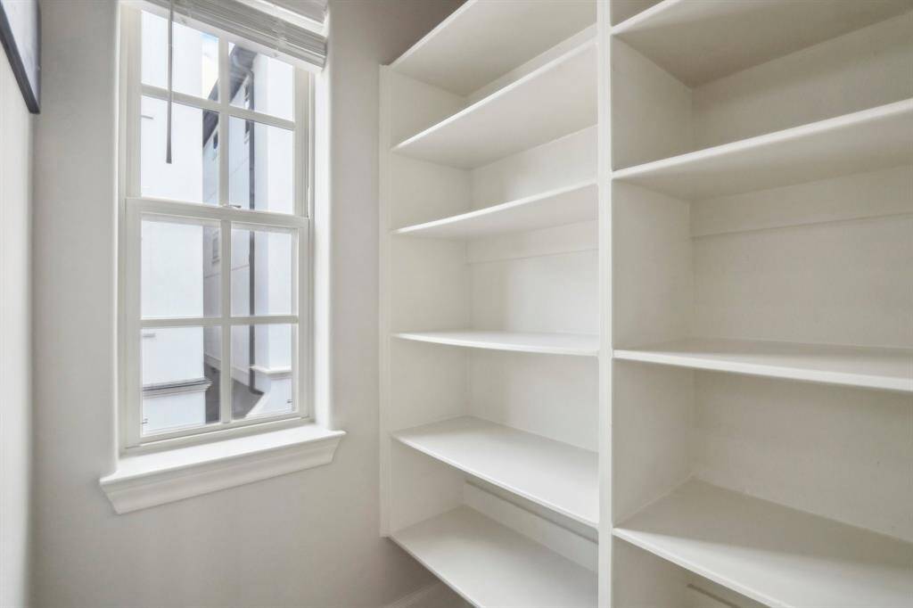 Walk in pantry with window and lots of shelving to store all your goods.