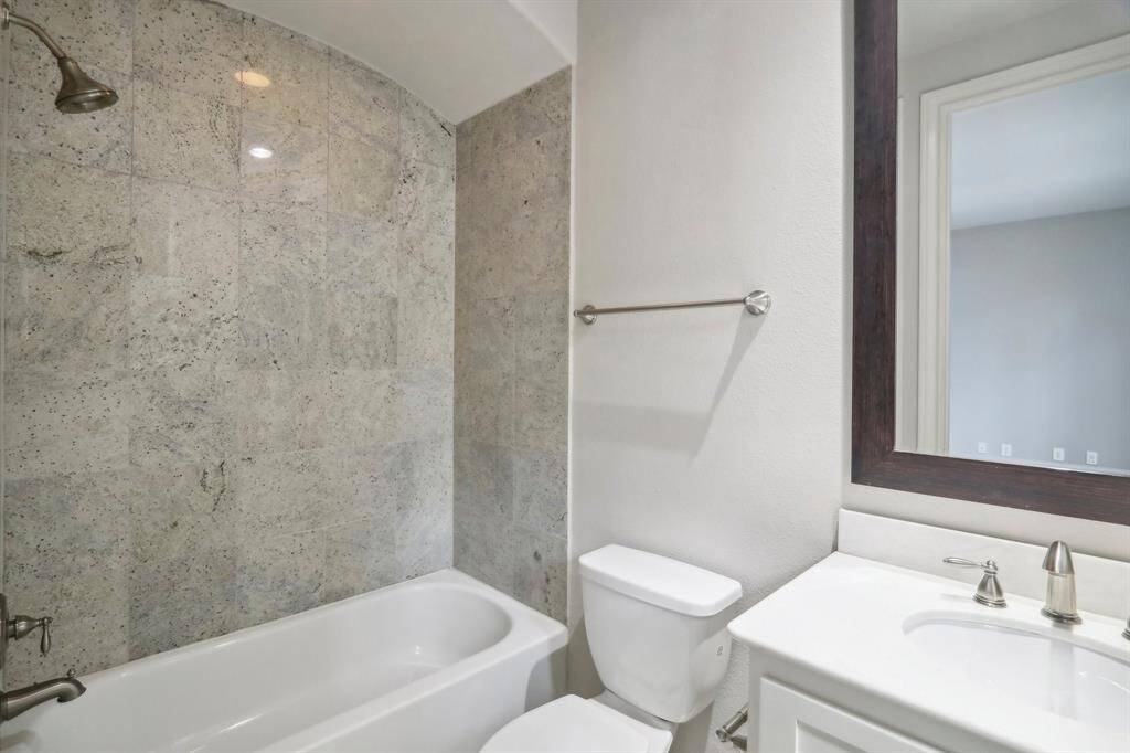 En suite bathroom on 1st floor with granite tile on walls and floors.