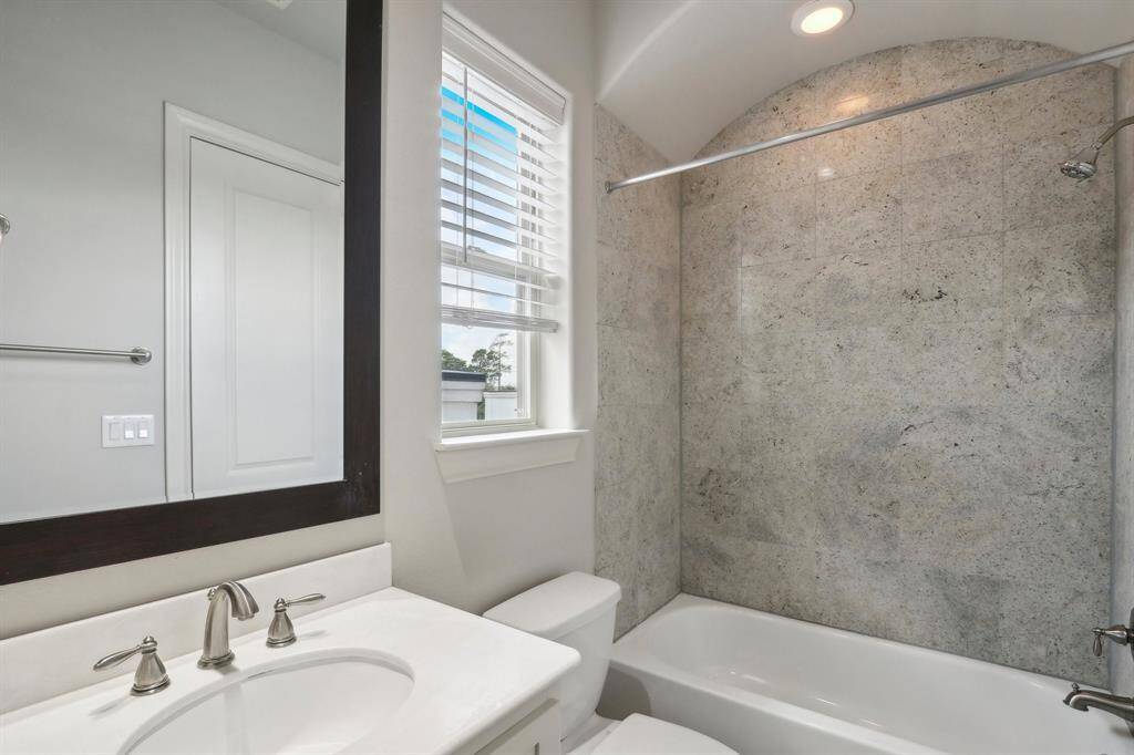 Shower/tub combo with granite floors and granite tile in the shower.