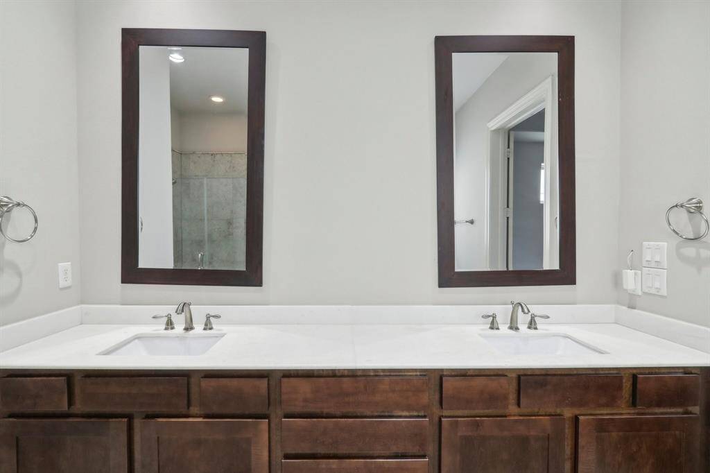 Beautiful wood cabinets with separate sinks and plenty of space to store personal items.
