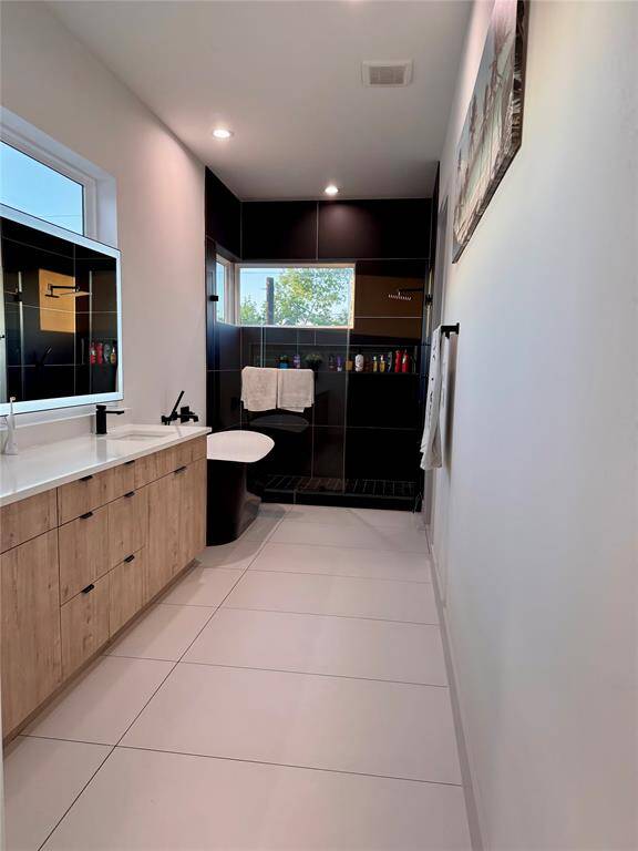 Primary bathroom with massive east facing window- joy to wake up to some natural light plus backlit and front-lit minimalist mirror. Massive countertop and electrical outlets in cabinet to always leave your hairdryer plugged in- away from sight !