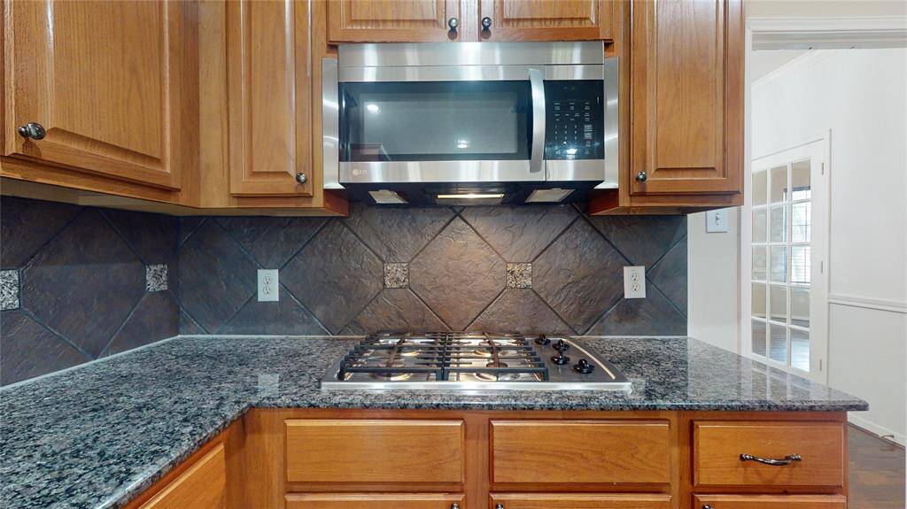 Elegant kitchen featuring a gas cooktop and sleek stainless-steel microwave.