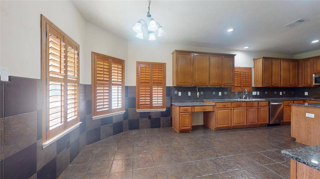 Spacious gourmet kitchen with elegant cabinetry, granite countertops, and abundant natural light. Perfect for culinary enthusiasts.