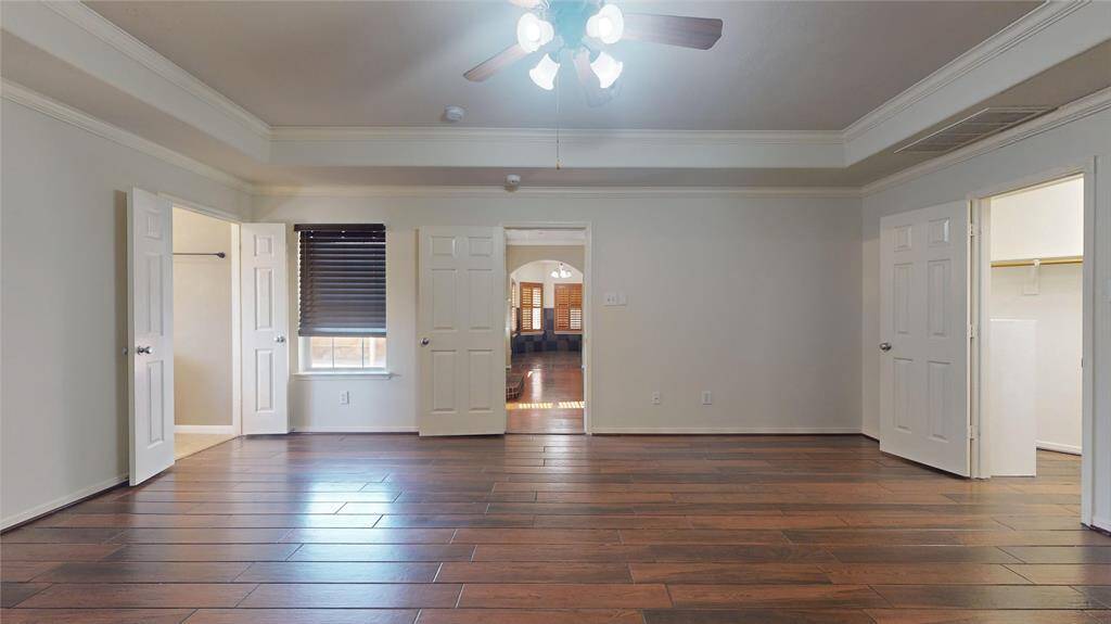 Luxurious primary bedroom featuring elegant tray ceiling and refined crown molding.