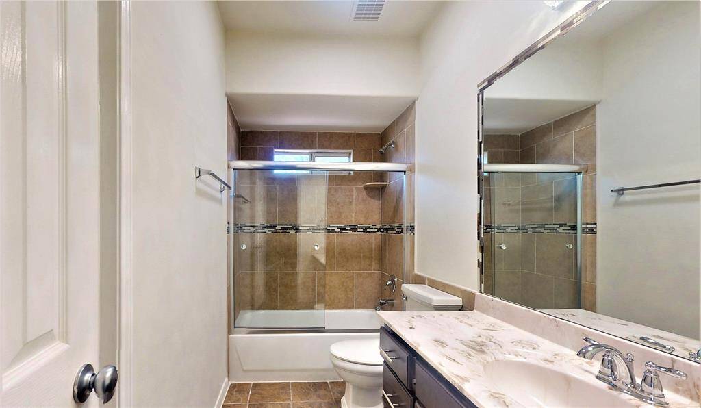 Elegant first-floor guest bathroom featuring modern tile work and a sleek vanity.