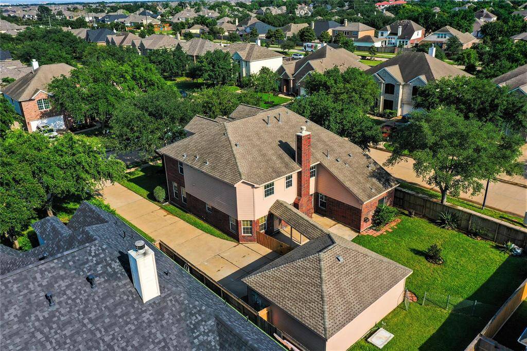 Expansive aerial view showcasing a spacious backyard and convenient detached garage.