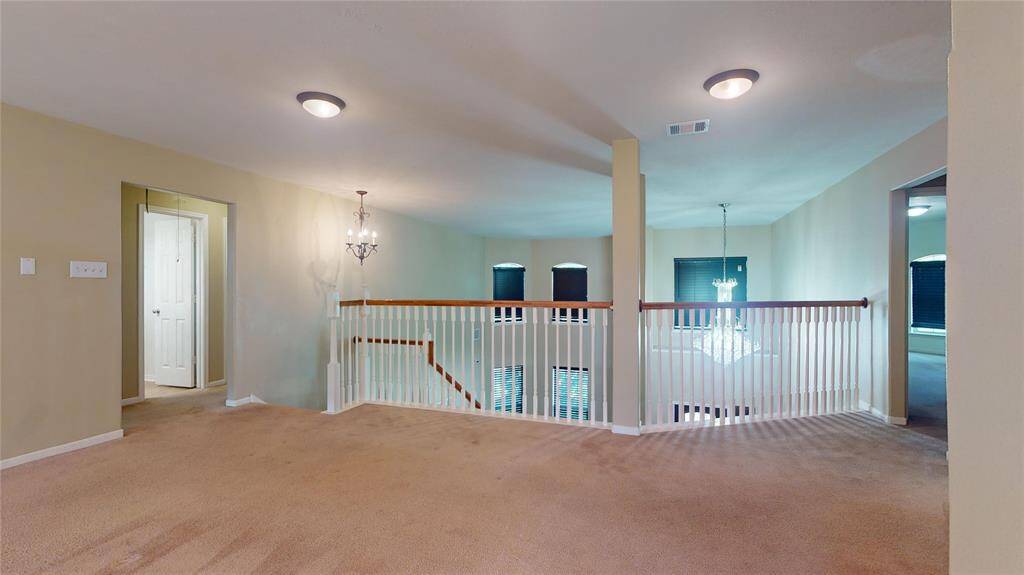 Expansive upstairs loft perfect for a cozy retreat or versatile home office, featuring elegant lighting and open views.