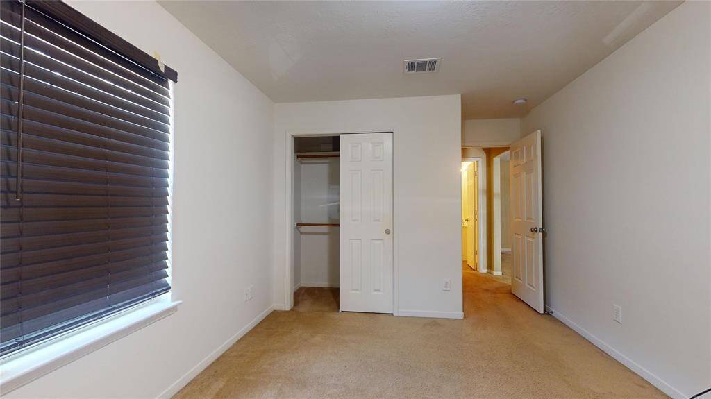 Cozy third guest bedroom with ample natural light and a convenient closet.