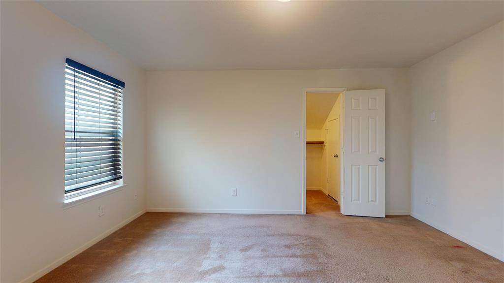 Spacious guest bedroom with natural light and a convenient closet.