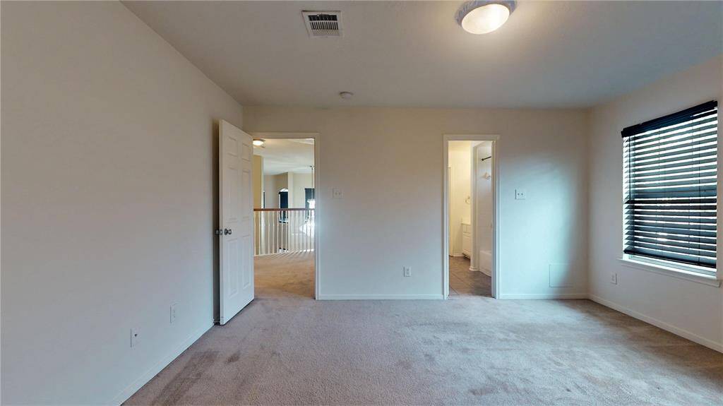 Inviting guest bedroom with ample natural light, perfect for relaxation.