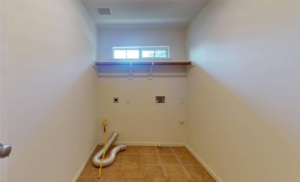 Convenient upstairs utility room with ample space for laundry and storage needs.