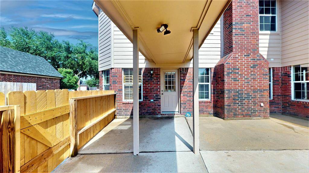 Charming back patio with a covered walkway leading to the detached garage.