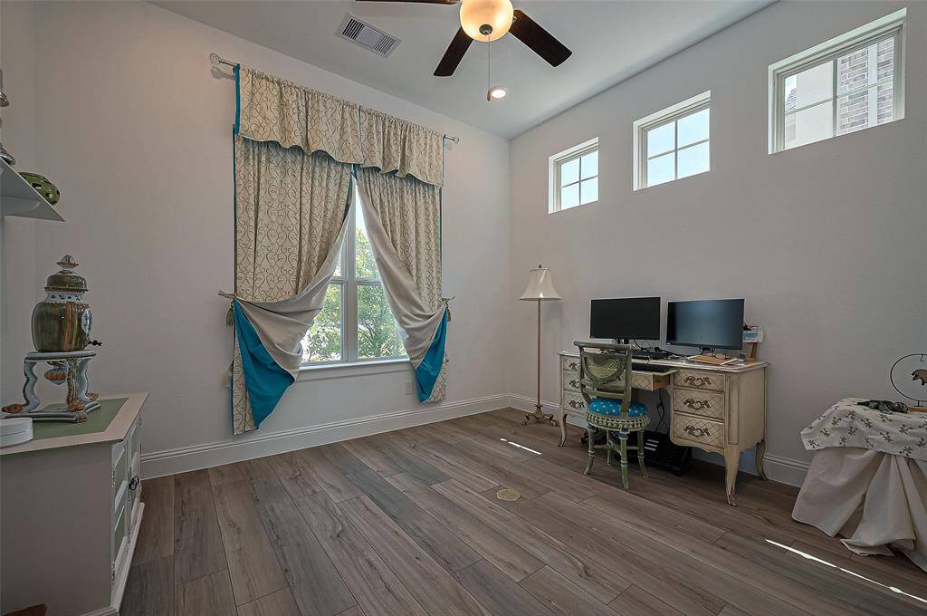 Cozy and bright study with elegant decor, featuring ample natural light from multiple windows. Ideal for productivity and relaxation.