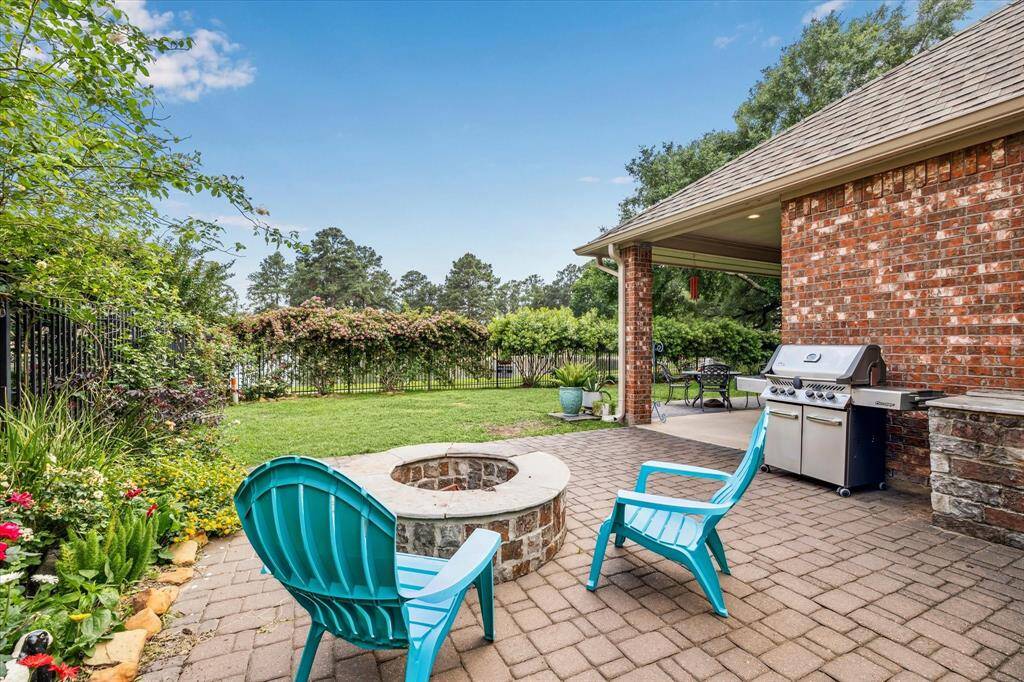 Two separate patios in the backyard, this with firepit and outdoor grilling area