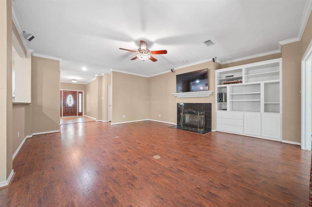 Large living room with built in shelving and a fire place. The TV and surround sound stay.
