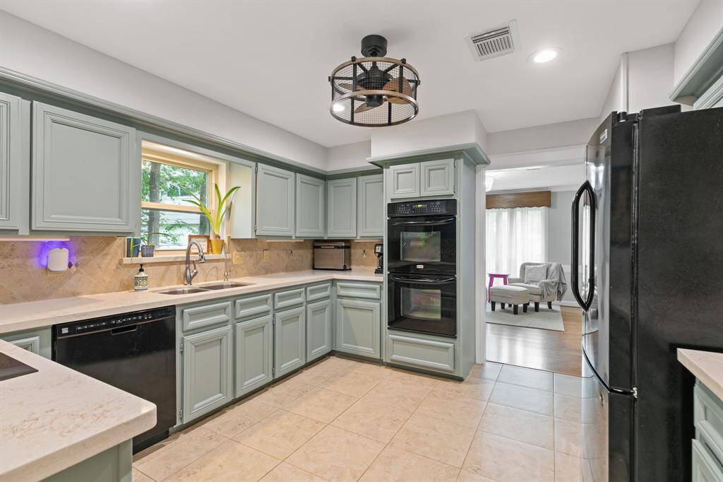 Black appliances, canned lighting and a fixture with "hidden fan" keeps you cool while cooking.
