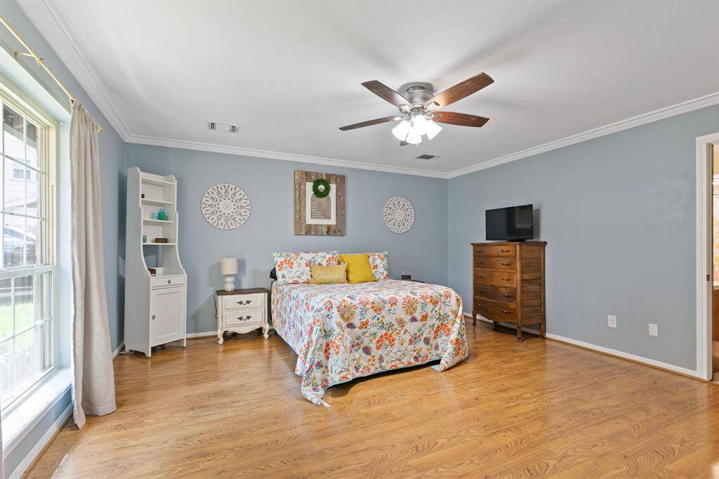Primary suite with wood look flooring and large picture window.