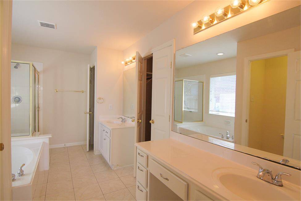 primary bath with dual sinks, glass shower, garden tub