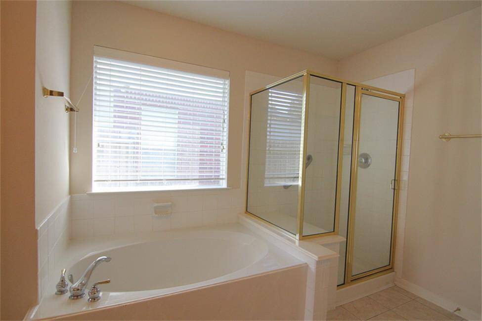 primary shower and tub; large window lets in plenty of light, blinds for privacy