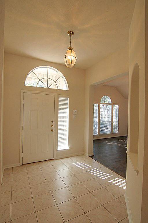 formal dining off bright, tiled entry with art niche