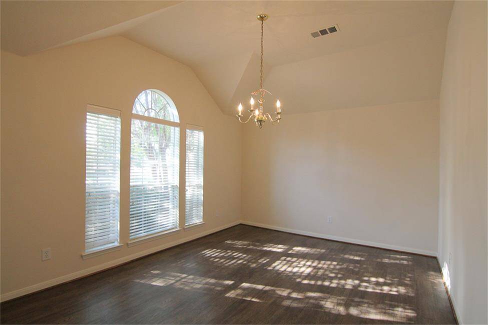 elegant formal dining room with faux-wood flooring, vaulted ceiling, chandelier (can also be used as formal living, music room, play room, etc.)