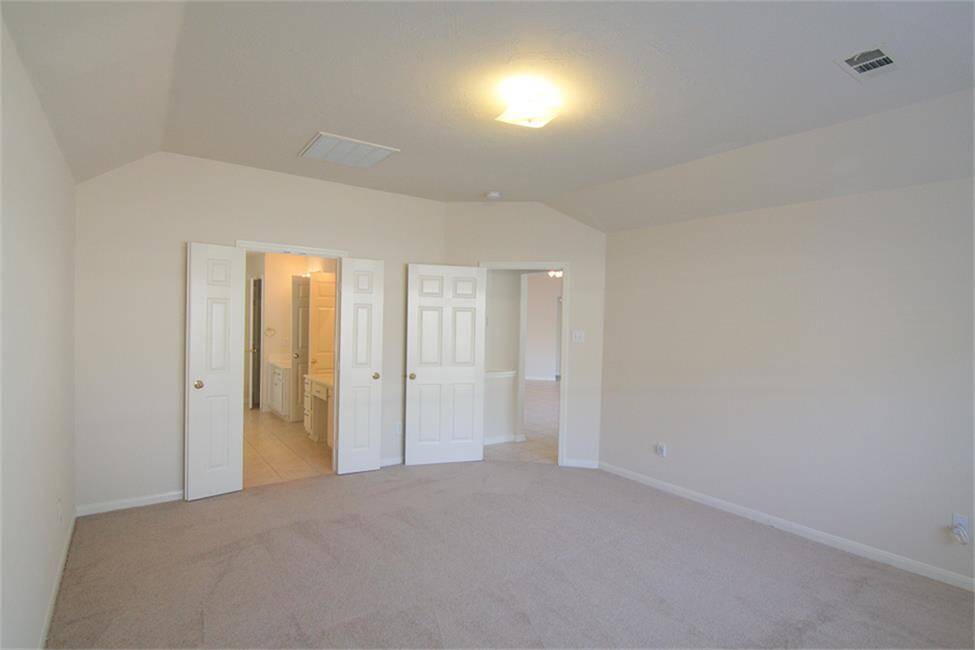 primary bedroom (reverse angle) with french doors to primary bath