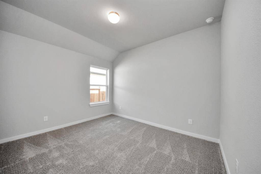 Secondary bedroom features plush carpeting, large windows that let in plenty of natural light, bright paint, and spacious closets. Sample photo of completed home with similar floor plan. Actual colors and selections may vary.