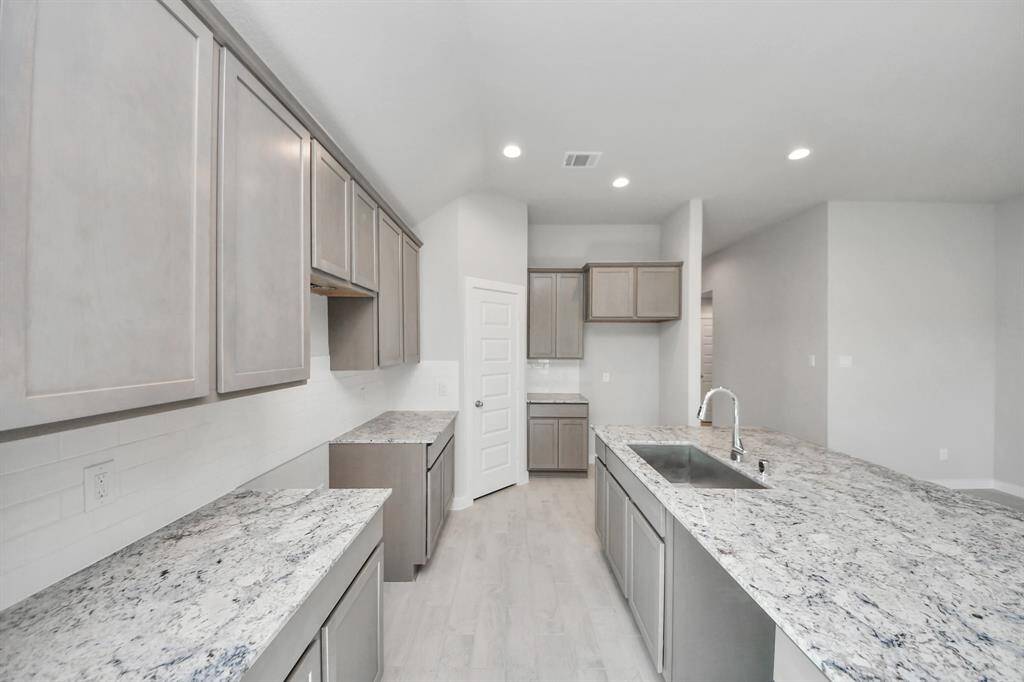 Discover another perspective of this stunning kitchen, generously appointed with an abundance of counter space.Sample photo of completed home with similar floor plan. Actual colors and selections may vary.