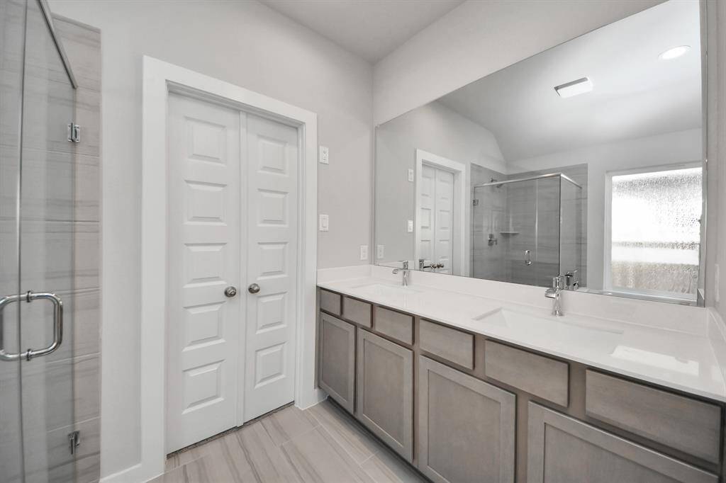 Elevate your daily routine at the elegant vanity, now equipped with double sinks, light countertops, modern hardware, and beautiful recessed lights. Sample photo of completed home with similar floor plan. Actual colors and selections may vary.