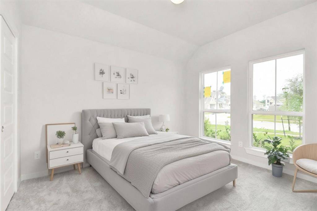 A cozy secondary bedroom with large windows, plush carpet, and spacious closets. The natural light and neutral colors create a serene, inviting atmosphere. Virtually staged. Sample photo of completed home with similar floor plan. Actual colors and selections may vary.