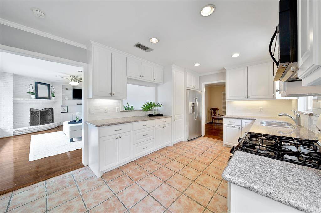 Kitchen appliances updated through the years with 4 burner gas stove and overlooking the family room.