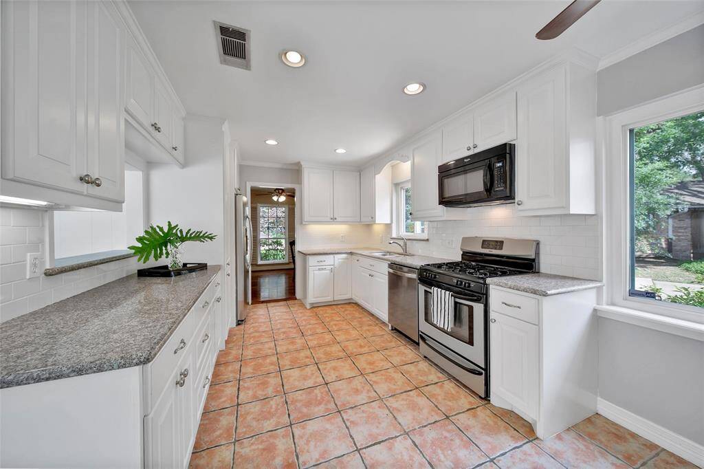 Kitchen appliances updated through the years with 4 burner gas stove and overlooking the family room.
