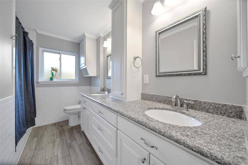 Secondary bathroom with double sinks, ample storage, and tub/shower combo.