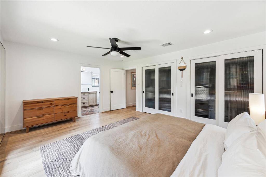 The primary suite features recessed lighting, Hunter ceiling fan, engineered wood floors 2 closets with reeded glass doors and an ensuite bath.