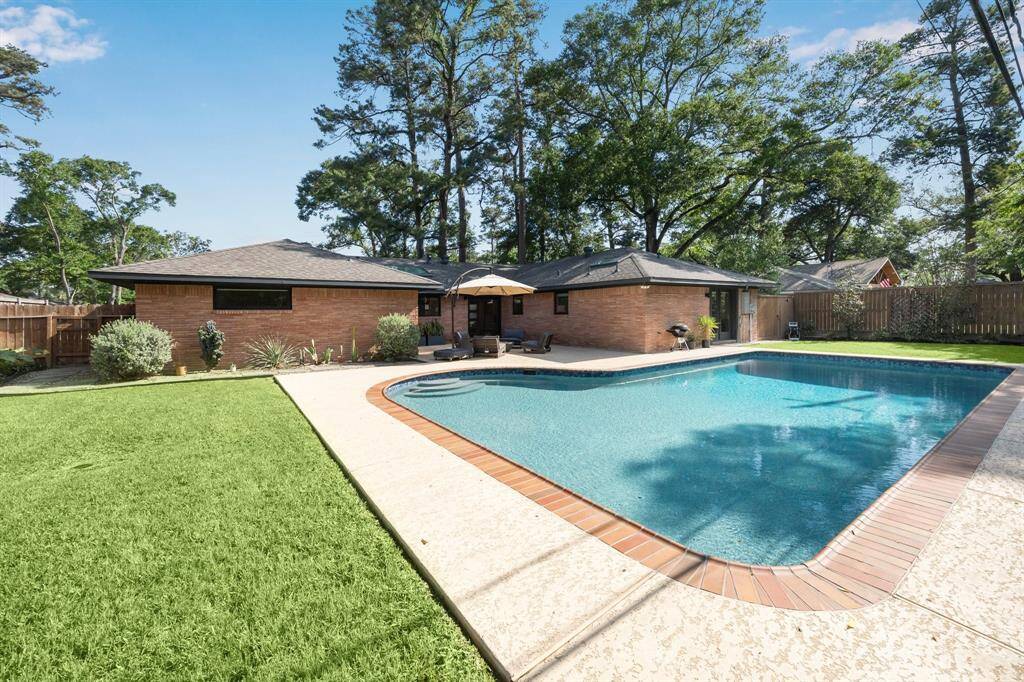 AMAZING backyard with patio space, two green spaces and a pool.