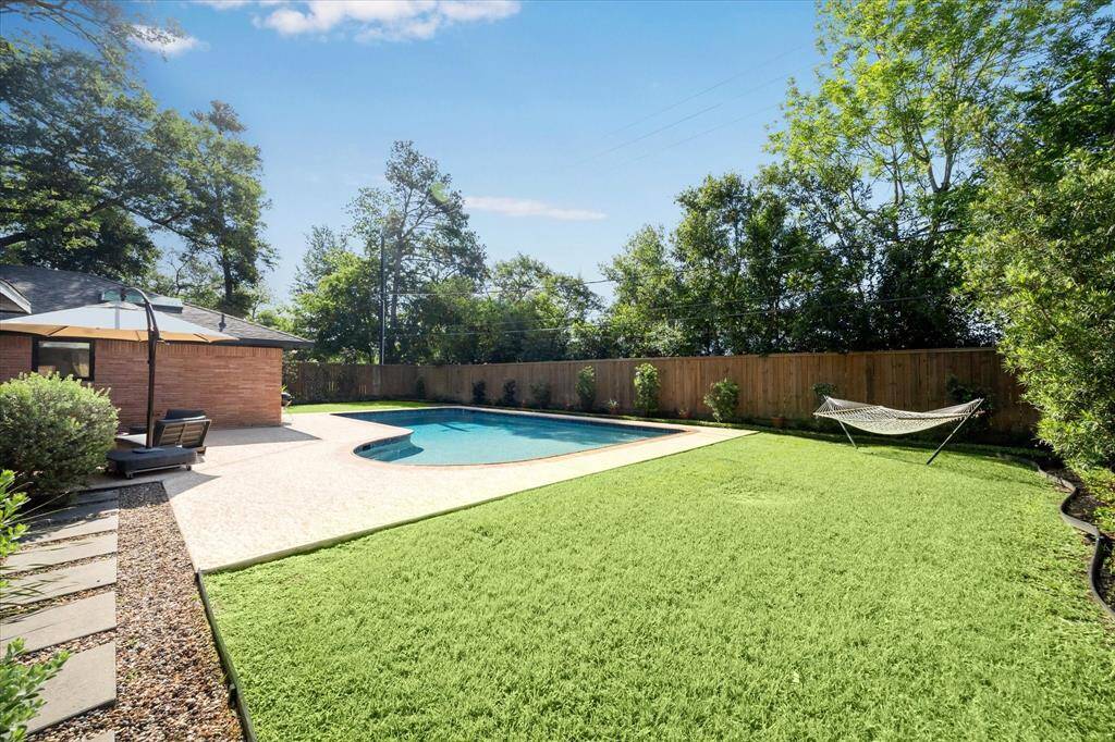 Look at this backyard! Custom-designed landscaping provides a gorgeous backdrop for the large yard and pool.