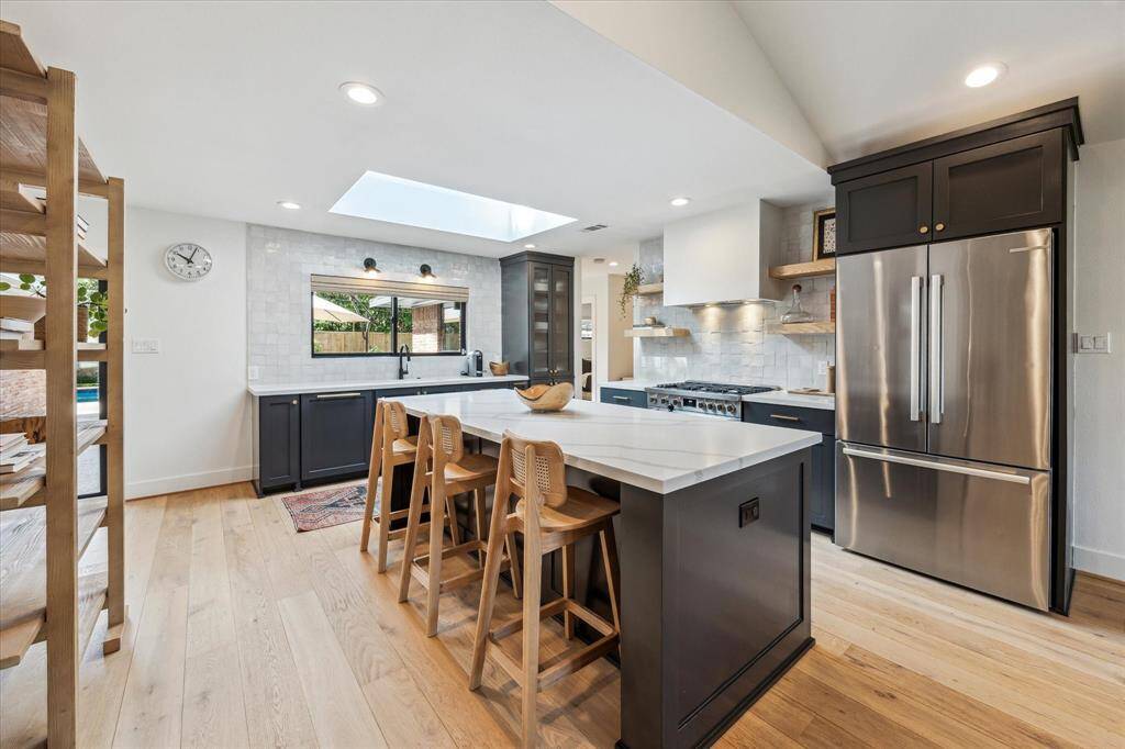 A large quartz island provides a breakfast bar for casual meals.