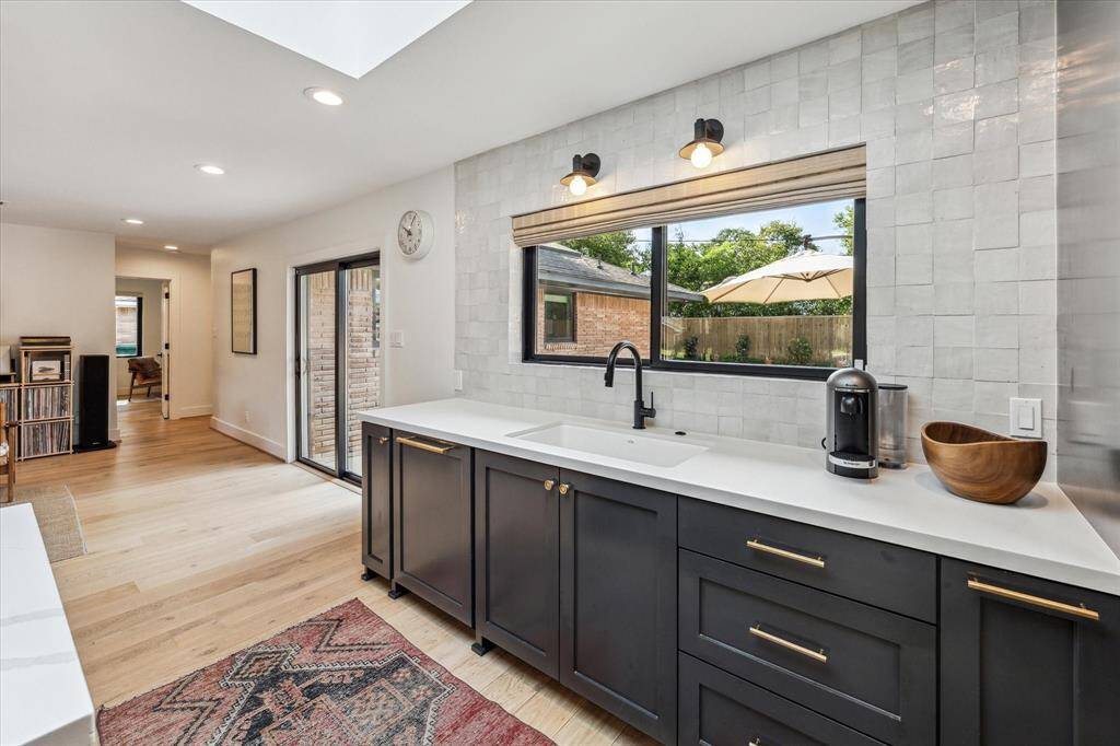 The kitchen features handmade Moroccan Zellige tile backsplash and unlacquered brass hardware from Rejuvenation.
