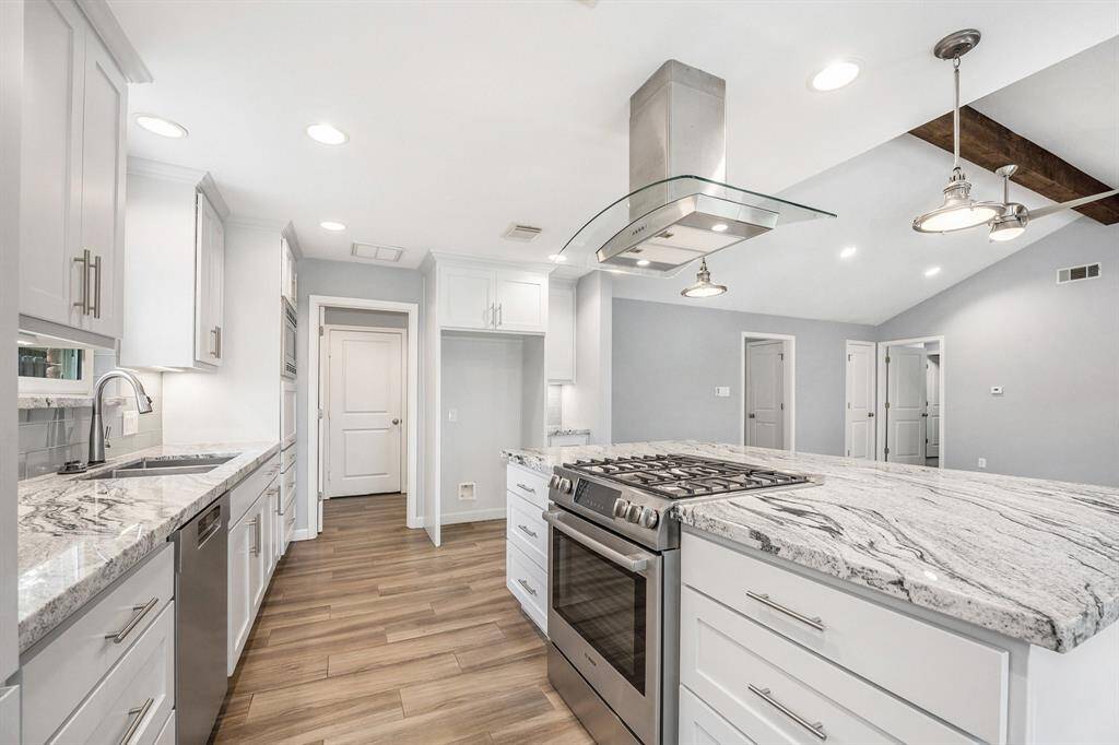 A different view from the kitchen that leads to the nice size laundry room with a folding table and a door to the 2 car garage.