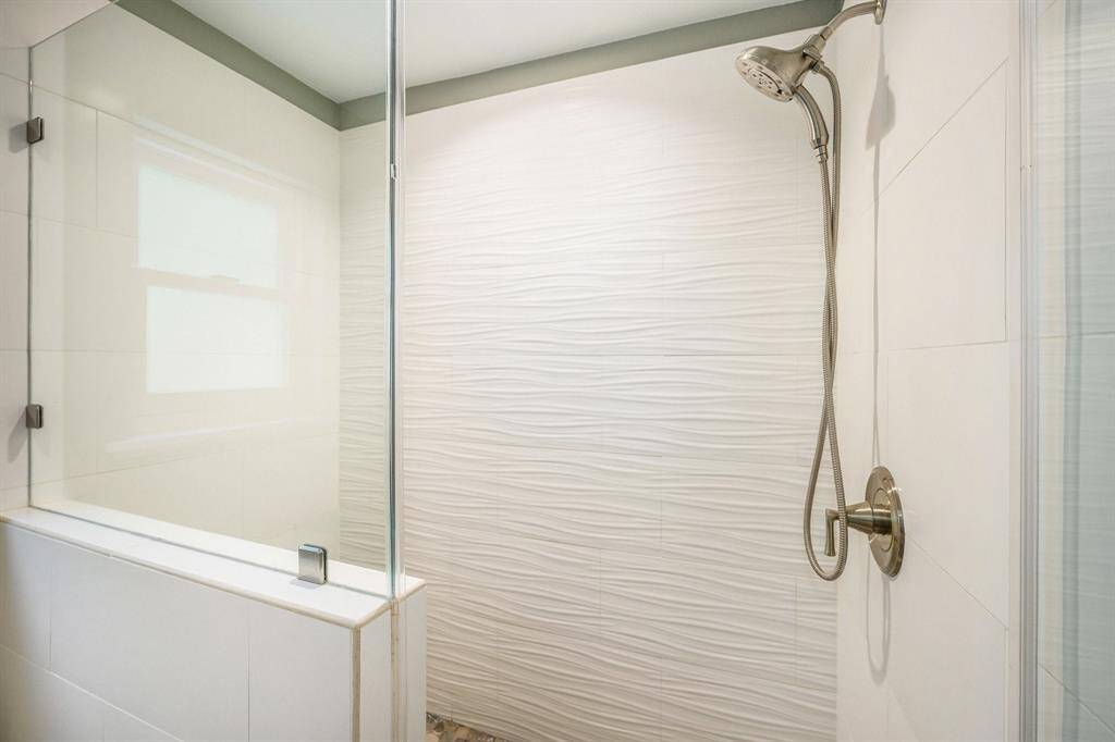 Pony wall with glass window and shower door has a nice fresh look in the oversized shower.